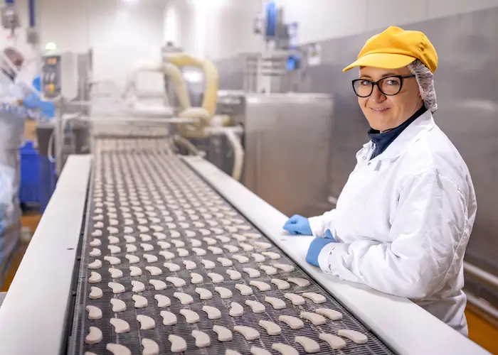 Two hands slicing ham